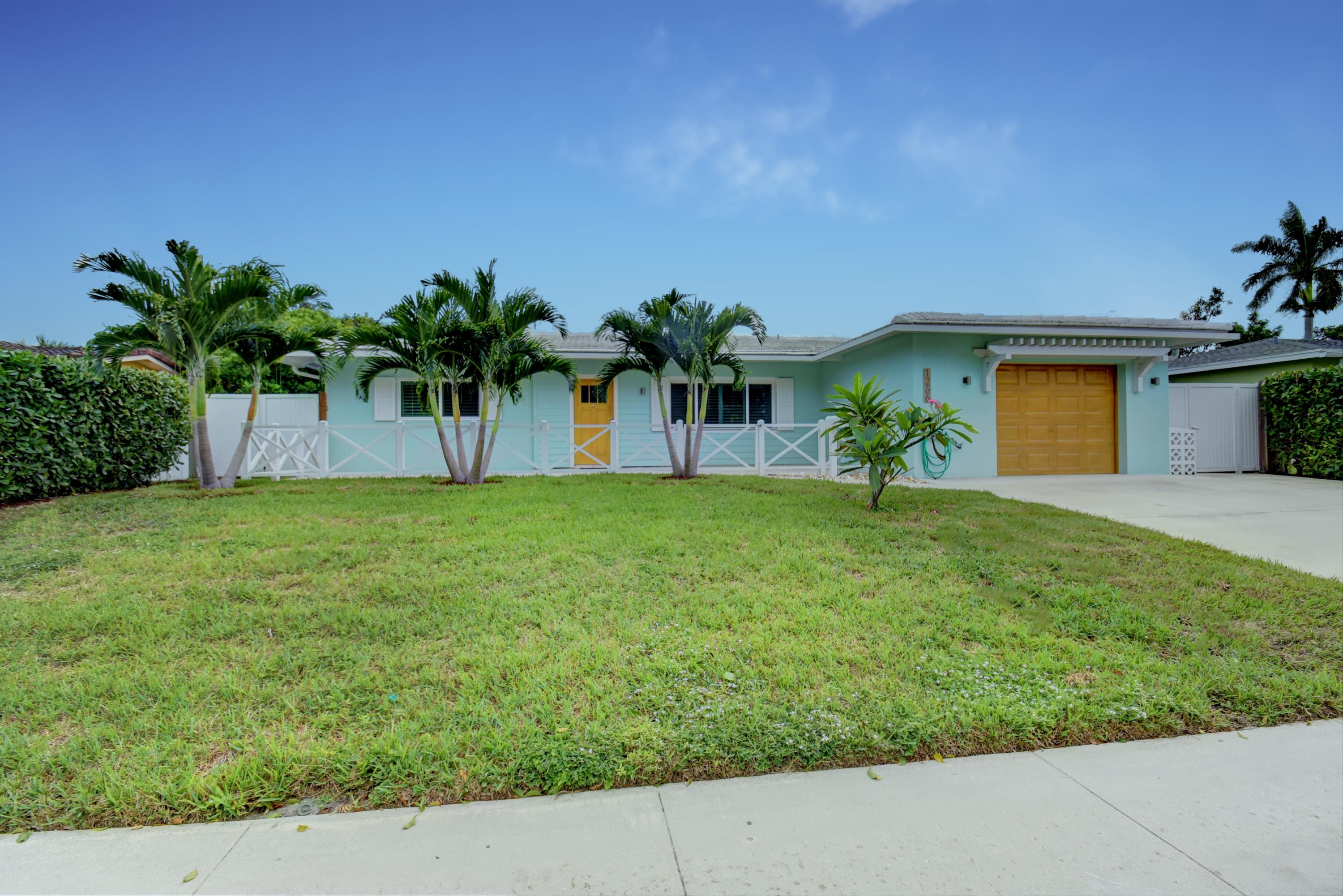 1266 Southwest 5th Street Boca Raton, FL 33486 - Photo 1 of 30 a front view of a house with a yard and a garage