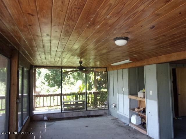 275 Huntington Shortcut Road Crescent City, FL 32112 - Photo 11 of 24 a view of an empty room with a sliding door and wooden floor