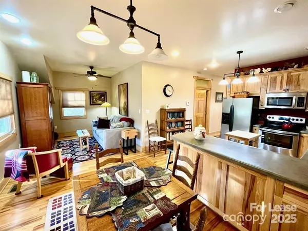 a large kitchen with lots of counter space a sink appliances and a living room view