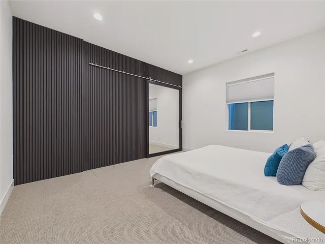 a bedroom with a bed and a mirror