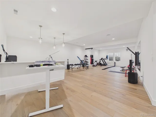 a kitchen with a sink a center island and a wooden floor