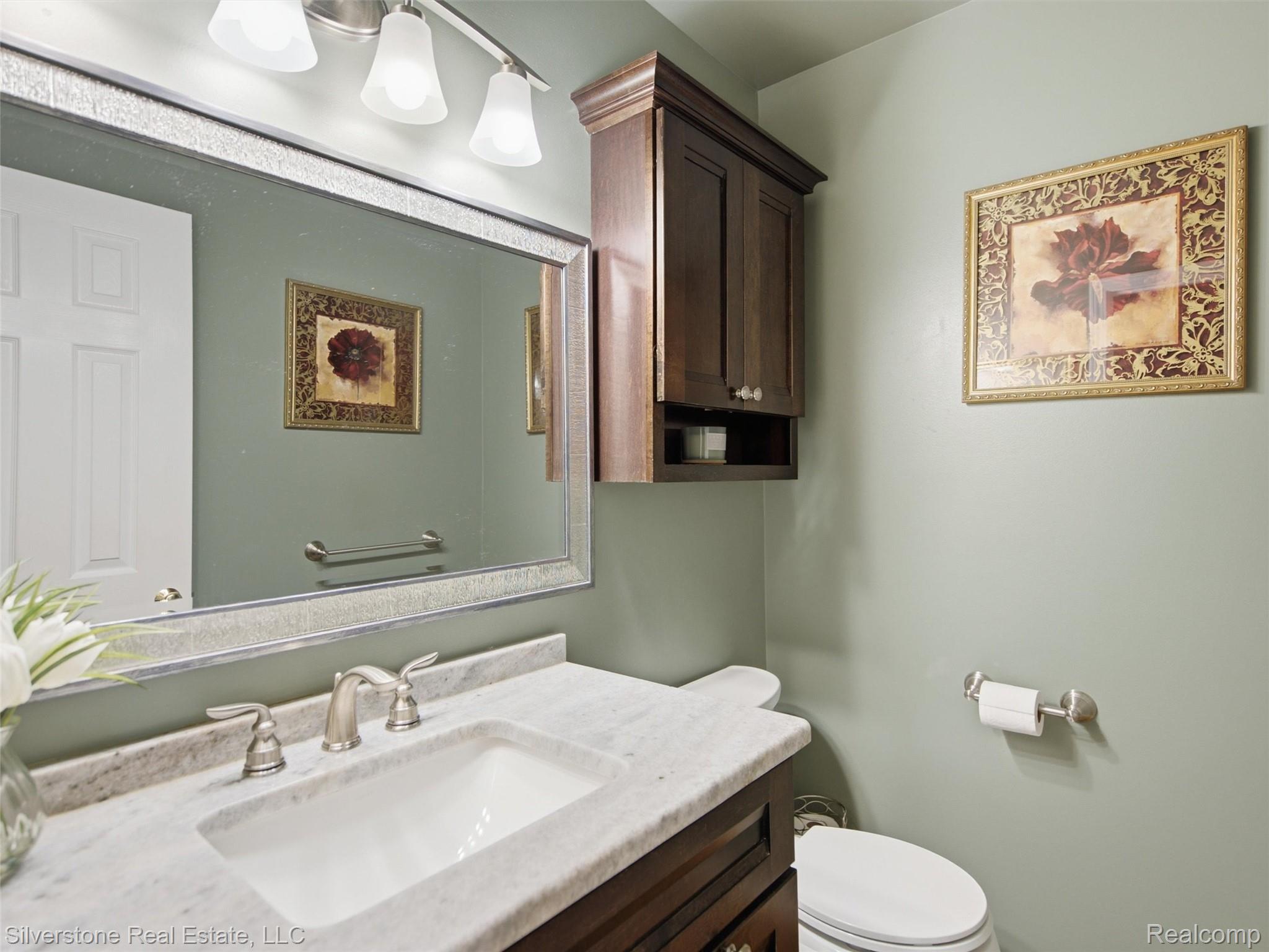 6577 Edith Court Troy, MI 48085 - Photo 28 of 61 Bathroom featuring a built-in wood vanity with a white countertop, undermount sink, and brushed nickel fixtures