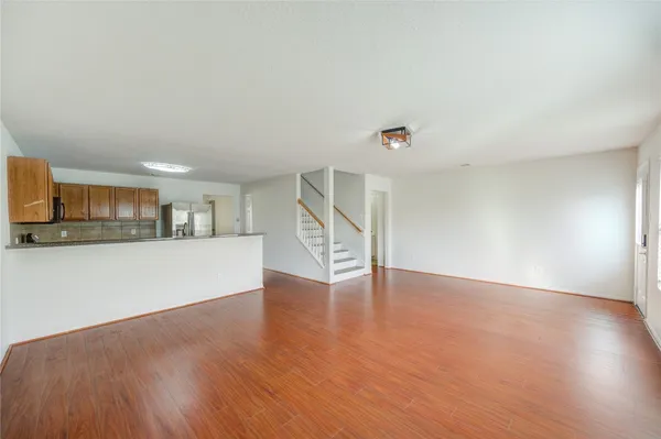 a view of empty room with wooden floor