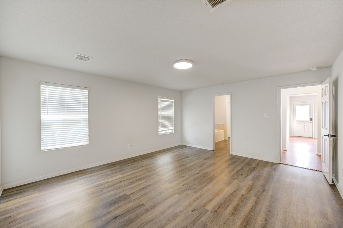18434 Ranch View Trail Houston, TX 77073 - Photo 16 of 35 an empty room with wooden floor and windows