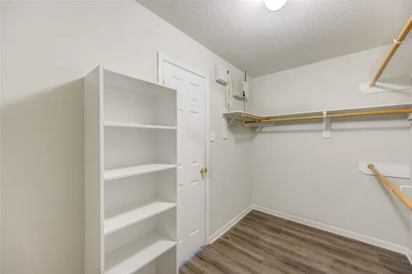 a view of walk in closet with empty racks