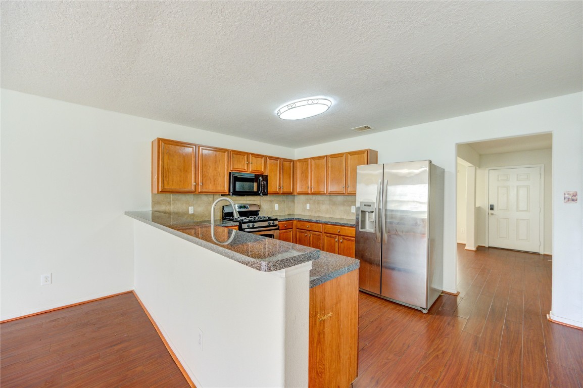 18434 Ranch View Trail Houston, TX 77073 - Photo 9 of 35 a kitchen with stainless steel appliances a refrigerator a sink a stove and cabinets