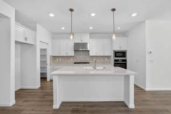 a kitchen with kitchen island a sink stainless steel appliances and cabinets