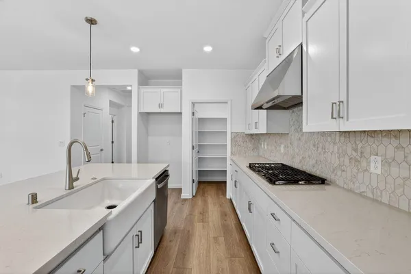 a kitchen with stainless steel appliances a sink stove and cabinets