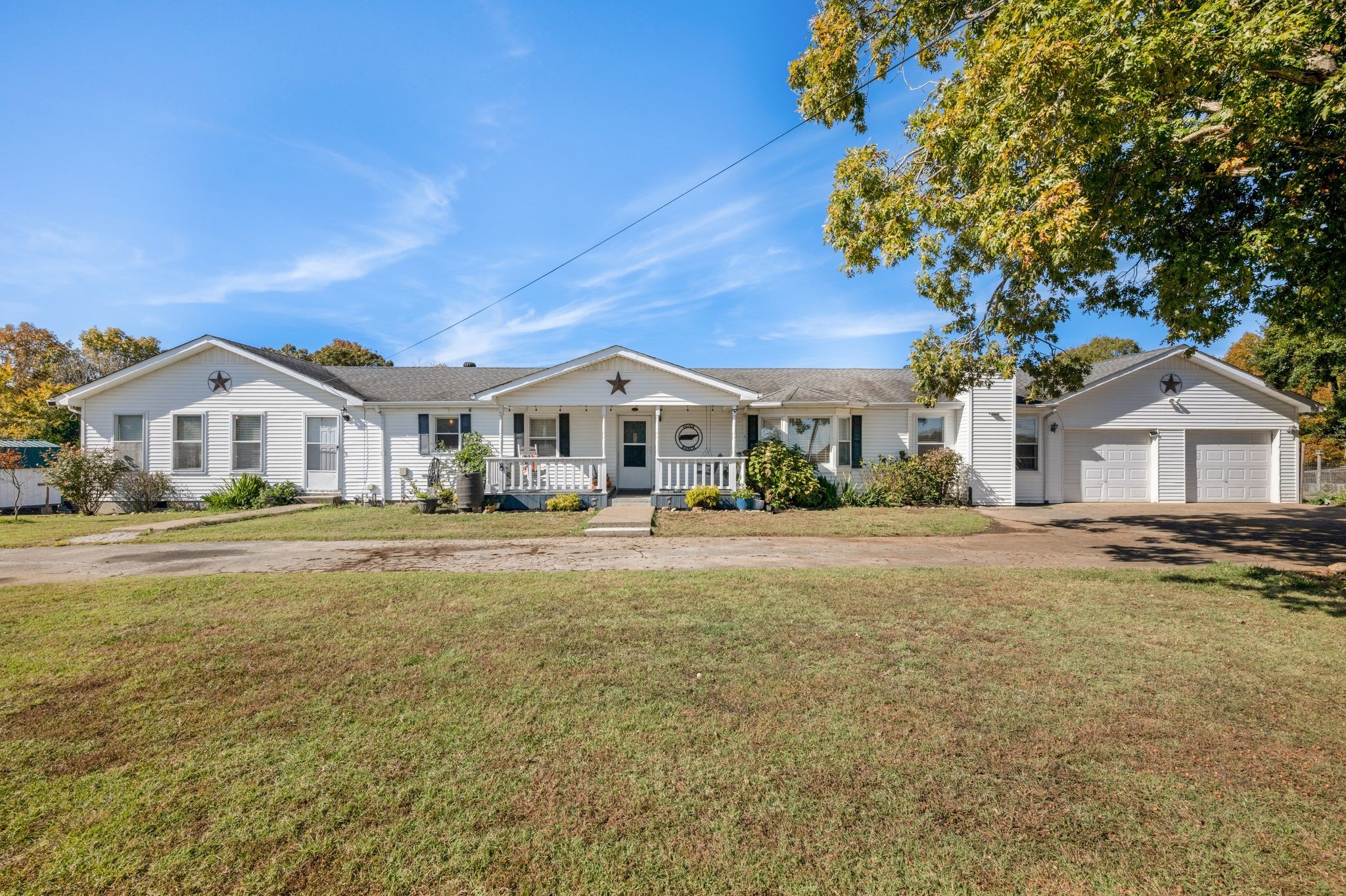 a white house with a big yard and large trees