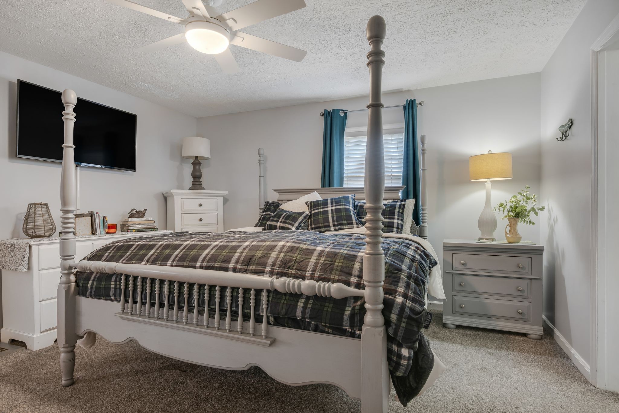 1971 Ridge Road McEwen, TN 37101 - Photo 18 of 40 a bedroom with a bed a flat screen tv and a chandelier