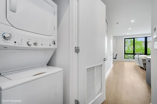 a view of washer and dryer with bathroom in the background