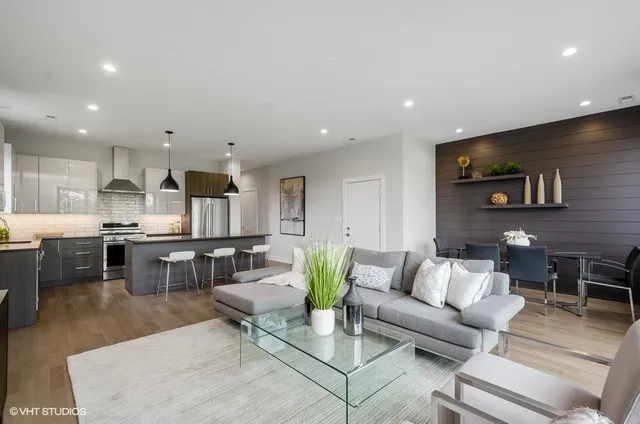 a living room with furniture kitchen view and a large window