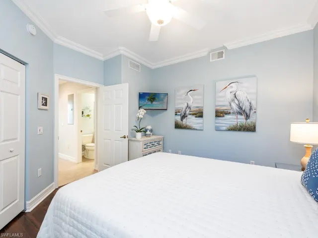 a bedroom with a large bed and a chandelier