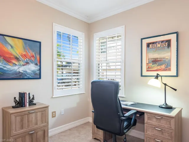a view of a workspace with furniture and a window