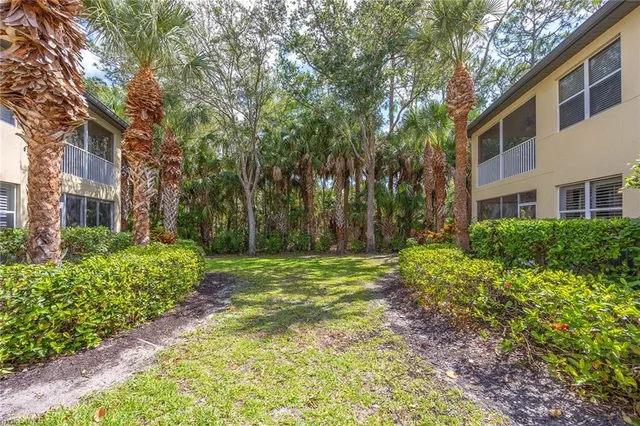 a backyard of a house with lots of green space and fountain