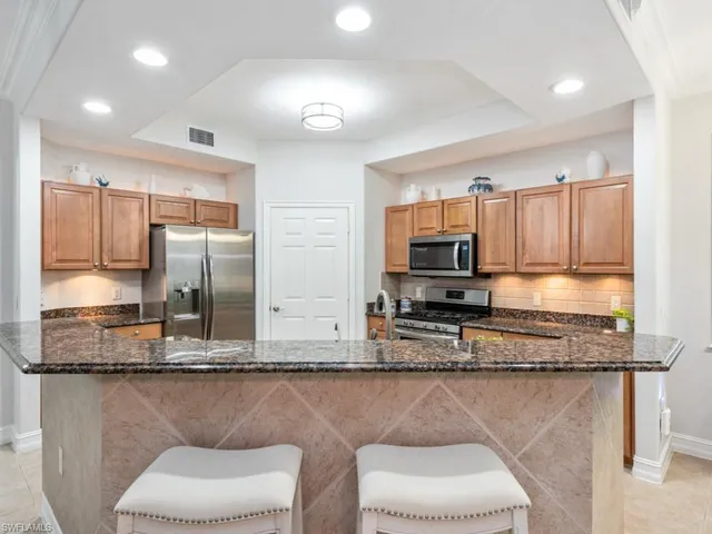 a kitchen with stainless steel appliances granite countertop a stove a sink and a microwave