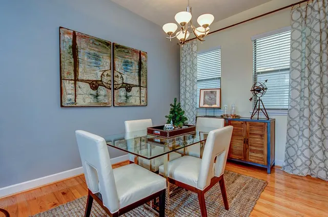 a dining room with furniture potted plants and wooden floor