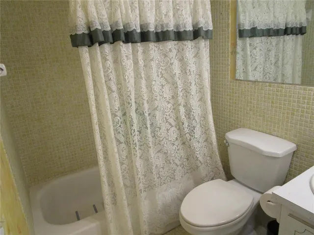 a white toilet sitting next to a shower