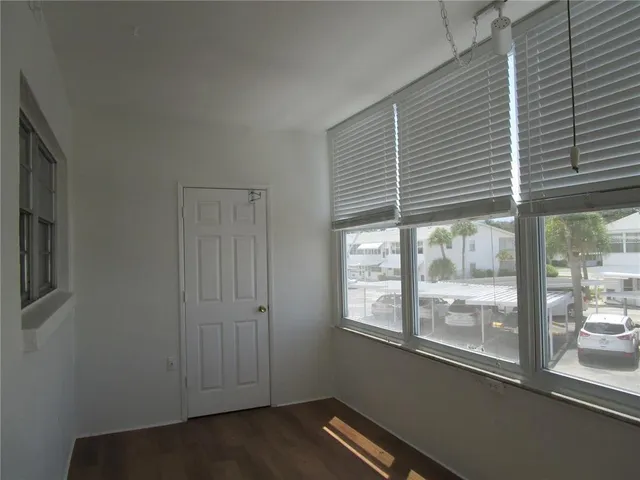a room with stainless steel appliances wooden floor and a large window