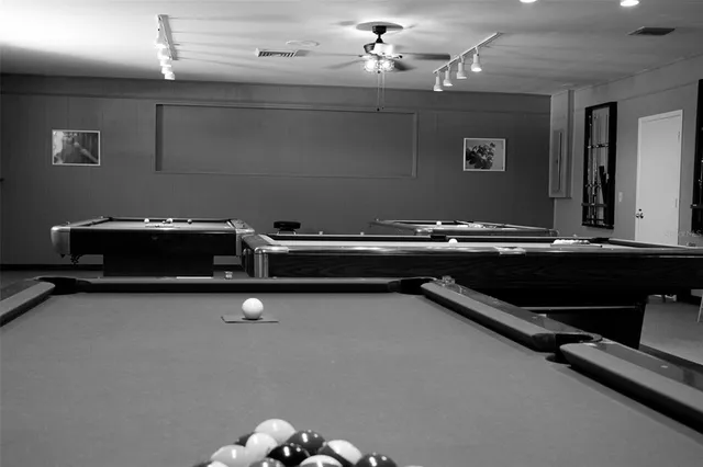 a kitchen with stainless steel appliances kitchen island granite countertop a table chairs and a refrigerator