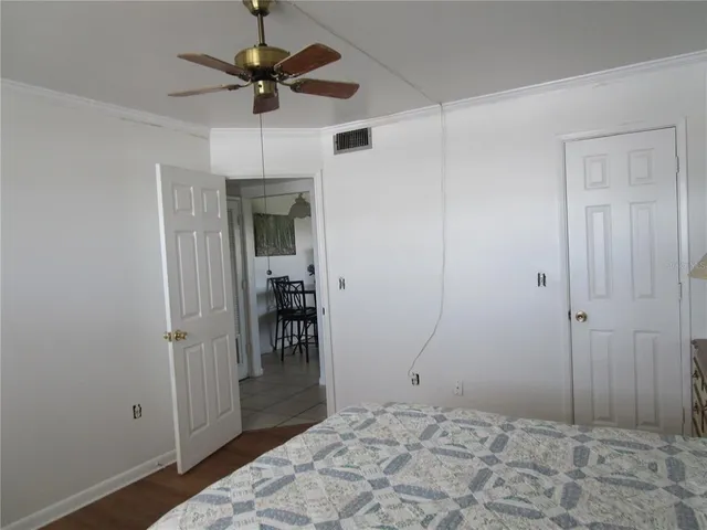 a bedroom with a dresser and a chandelier fan