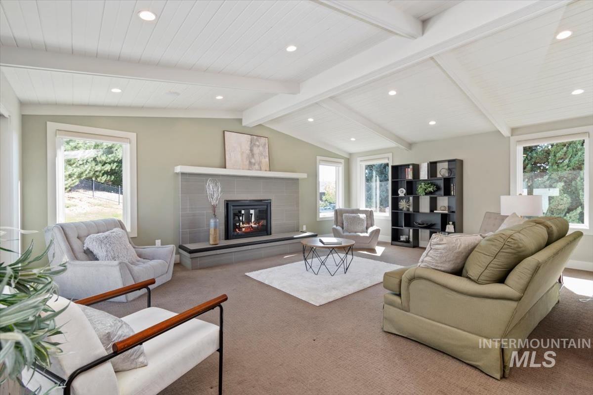 709 East Braemere Road Boise, ID 83702 - Photo 5 of 50 Vaulted ceiling with exposed beams, recessed lighting, floor-to-ceiling tiled fireplace, and multiple large windows