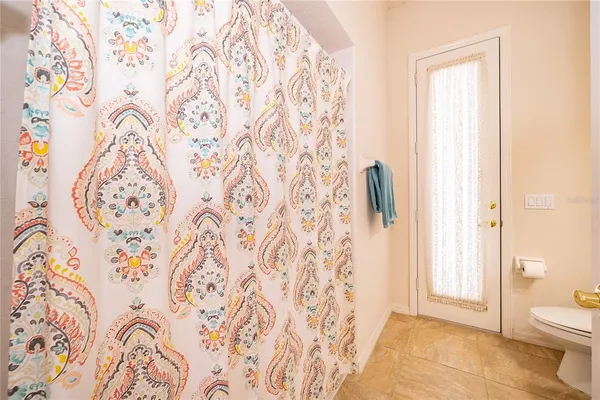 a bathroom with a toilet and a shower curtain