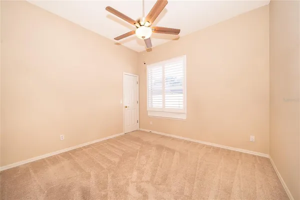 an empty room with a window and a fan