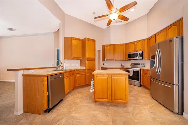 a kitchen with stainless steel appliances granite countertop a refrigerator a stove top oven a sink and dishwasher
