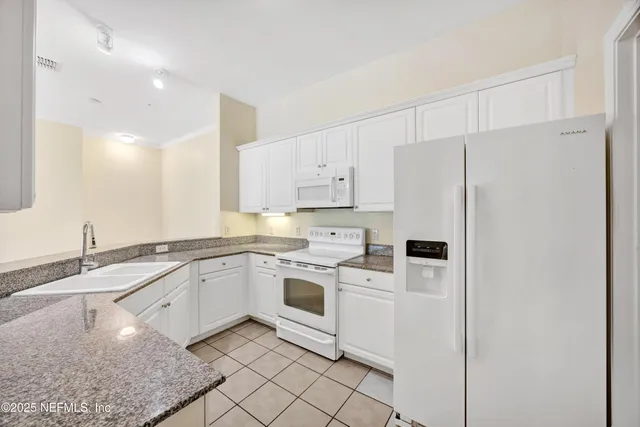 a kitchen with granite countertop stainless steel appliances white cabinets granite counter tops and a sink