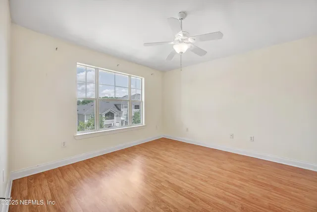 a view of empty room with wooden floor