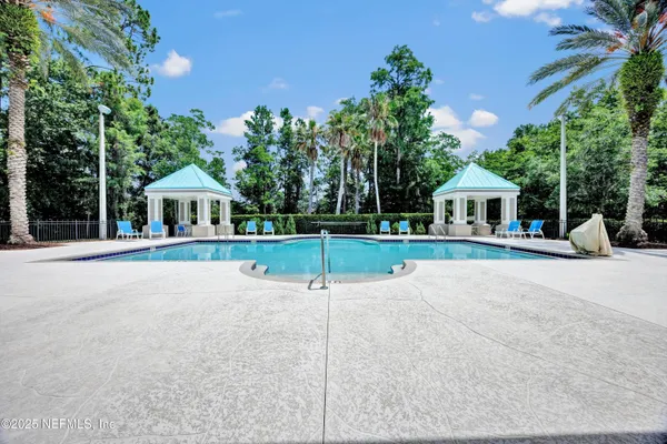 a view of a backyard with swimming pool and sitting area
