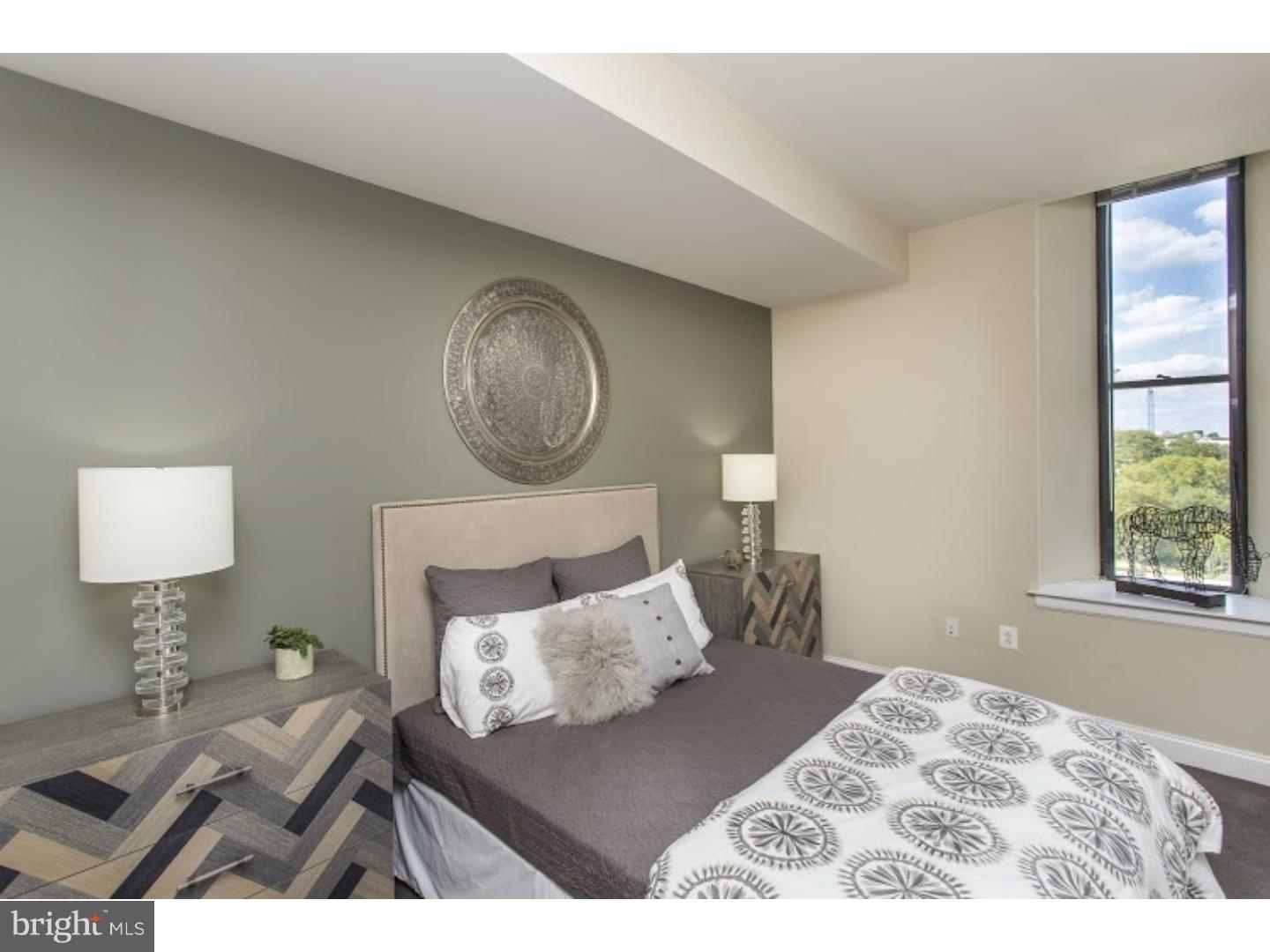 230-38 North 21st Street, Unit 604 Philadelphia, PA 19103 - Photo 11 of 20 a bedroom with a bed and a lamp