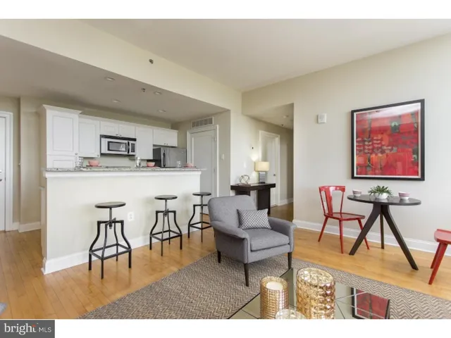 a living room with furniture and a dining table with wooden floor