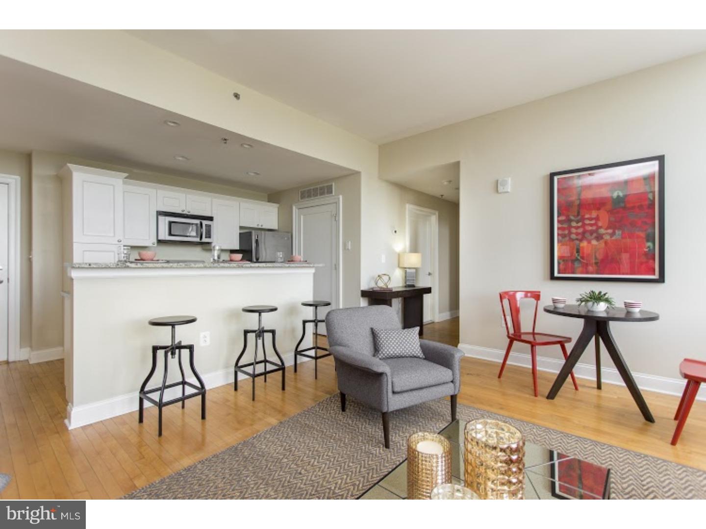 230-38 North 21st Street, Unit 604 Philadelphia, PA 19103 - Photo 2 of 20 a living room with furniture and a dining table with wooden floor