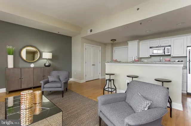 a living room with furniture and a wooden floor
