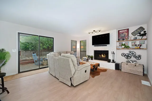 a living room with furniture a fireplace and a flat screen tv