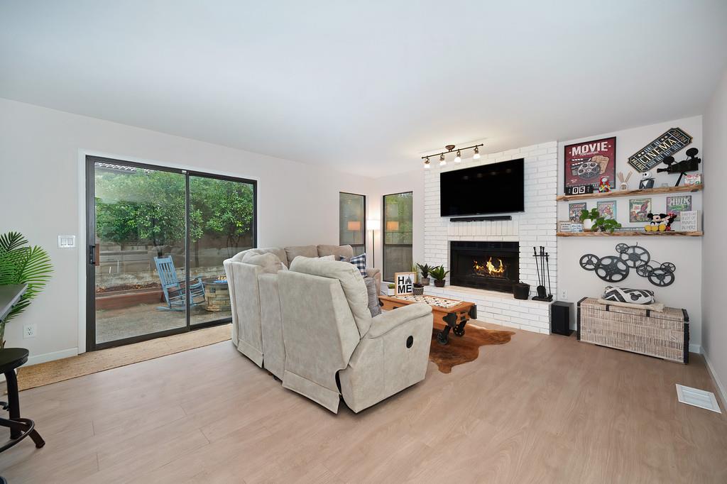 8477 Rick Mary Court Fair Oaks, CA 95628 - Photo 12 of 48 a living room with furniture a fireplace and a flat screen tv