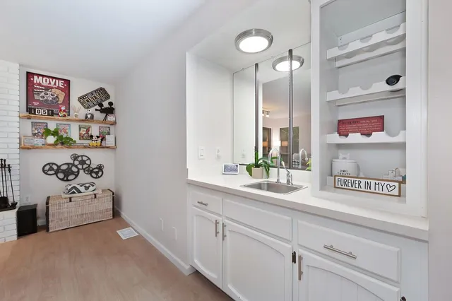 a hallway with white cabinets and window