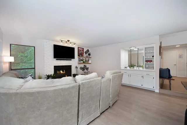 a living room with furniture a fireplace and a flat screen tv