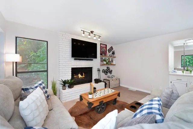 a living room with furniture a flat screen tv and a fireplace