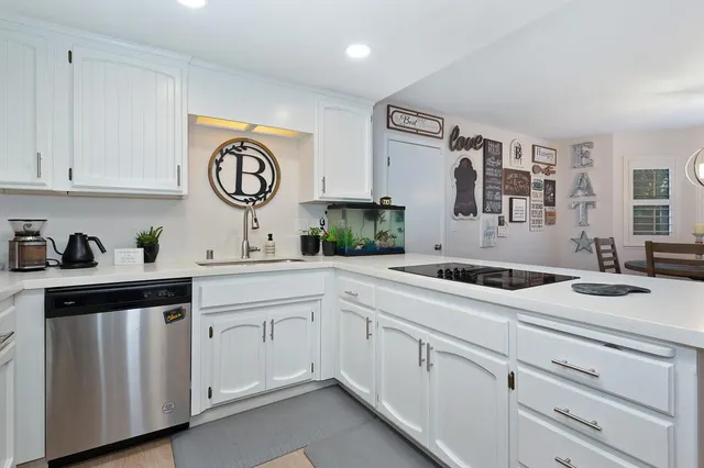 a kitchen with white cabinets and sink
