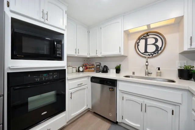 a kitchen with cabinets stainless steel appliances and a sink