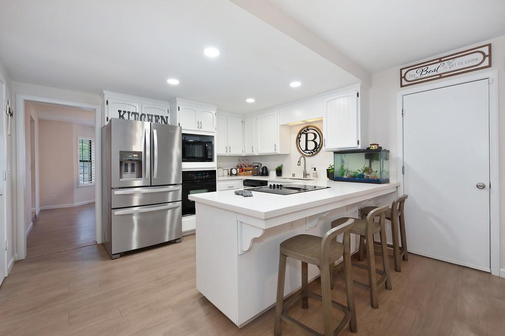 8477 Rick Mary Court Fair Oaks, CA 95628 - Photo 21 of 48 a kitchen with kitchen island a refrigerator stove and microwave