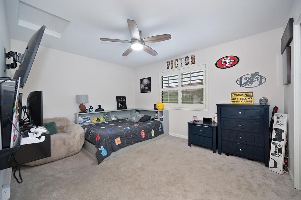8477 Rick Mary Court Fair Oaks, CA 95628 - Photo 27 of 48 a bedroom with a bed and a chandelier