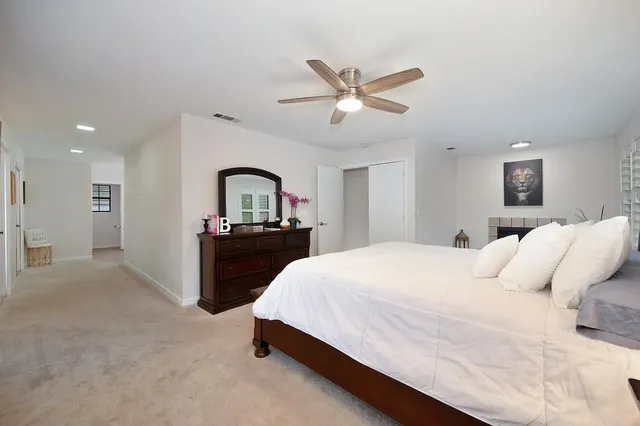 a bedroom with a large bed and a chandelier