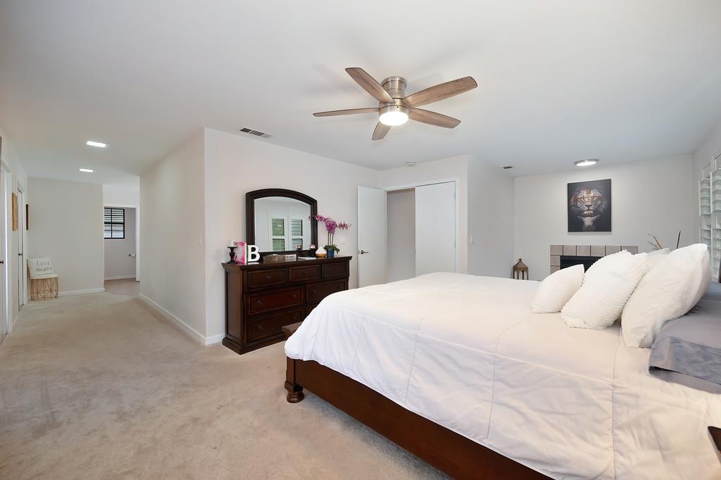 8477 Rick Mary Court Fair Oaks, CA 95628 - Photo 34 of 48 a bedroom with a large bed and a chandelier