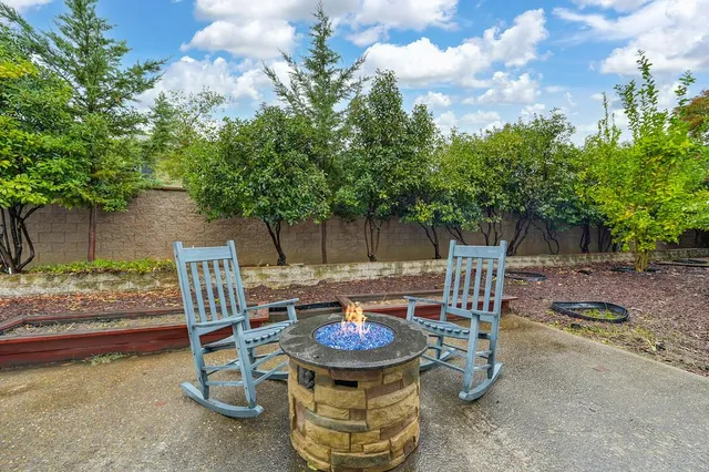 a view of a chairs and table in backyard