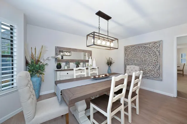 a dining room with furniture potted plants and wooden floor