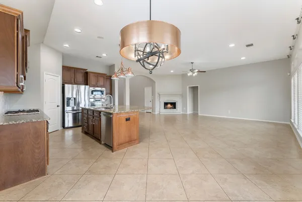 a kitchen with kitchen island granite countertop a stove a sink and cabinetry